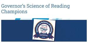 Science of Reading Champion Award pictured, blue and read in a circle with a ribbon going across.