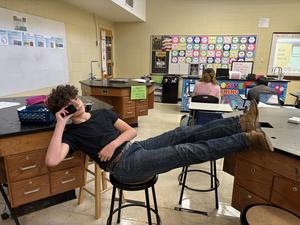 One student "phoning a friend" with his feet propped up