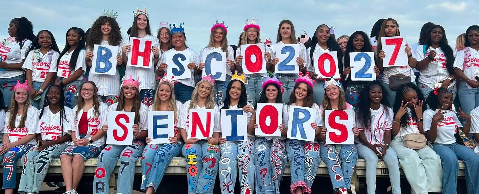 A group of seniors poses with colorful letters spelling 'BHSC 2027 SENIORS'.