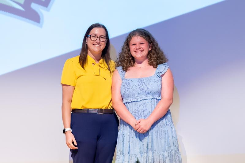 curly haired senior receiving scholarship from a pitt representative