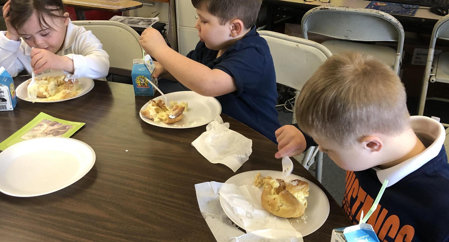 Students eating cream puffs