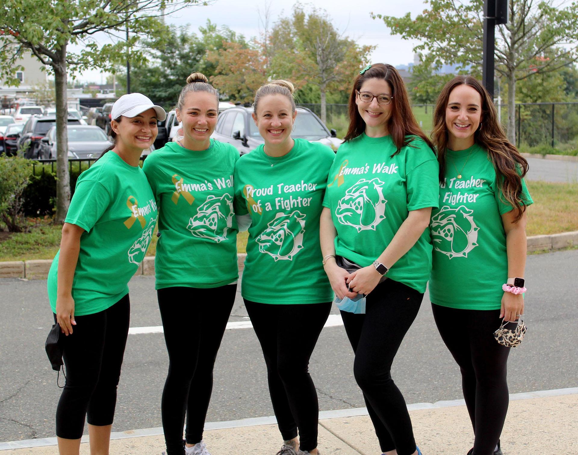 A group of EPS teachers standing on the sidewalk, wearing green t-shirts