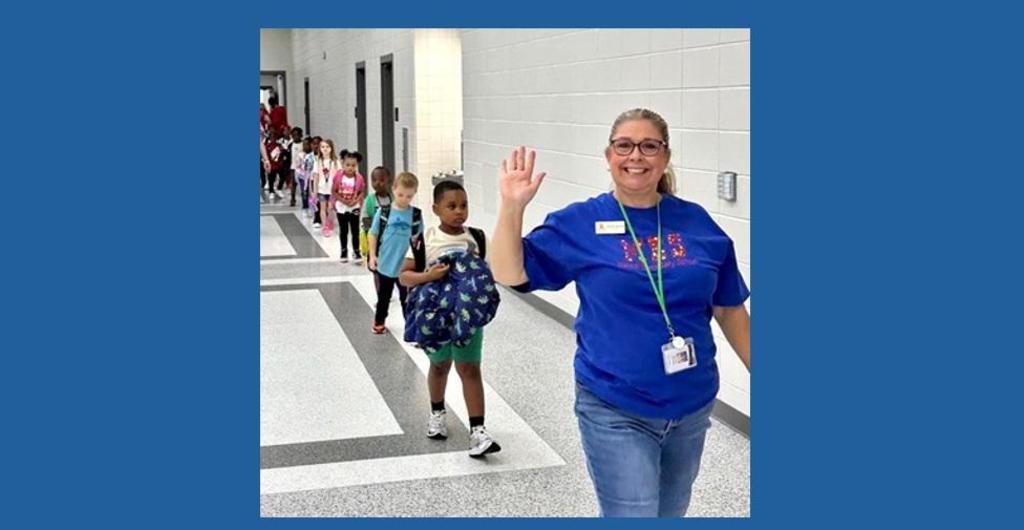 Happy teacher and class walking down the hallway