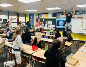 high school student shows off physical abilities for kids in class
