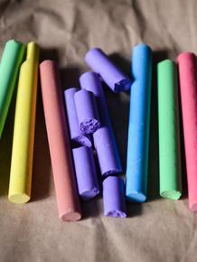 Colorful chalk pieces scattered on a brown fabric surface.