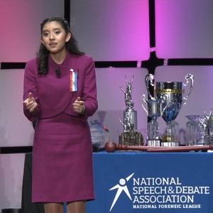 Student giving speech from stage at finals