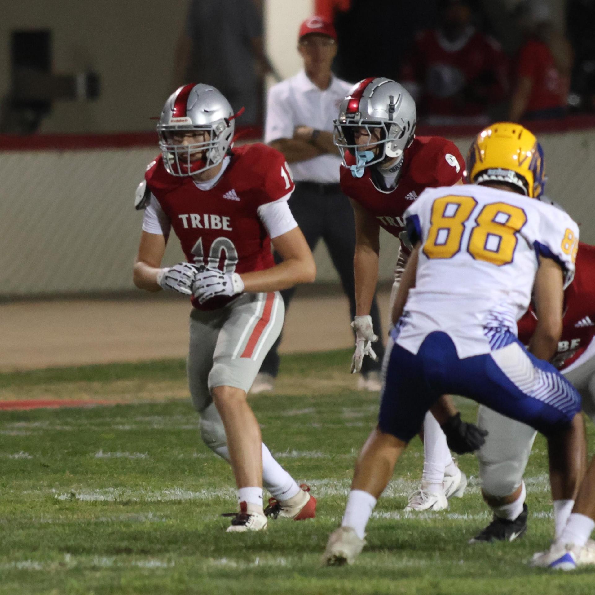 Varsity football players in action against Parlier 140