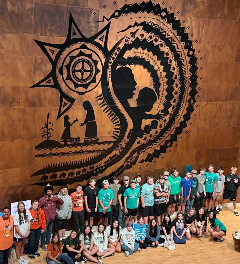 Native American Club trip to museum, photo of group with large wall art