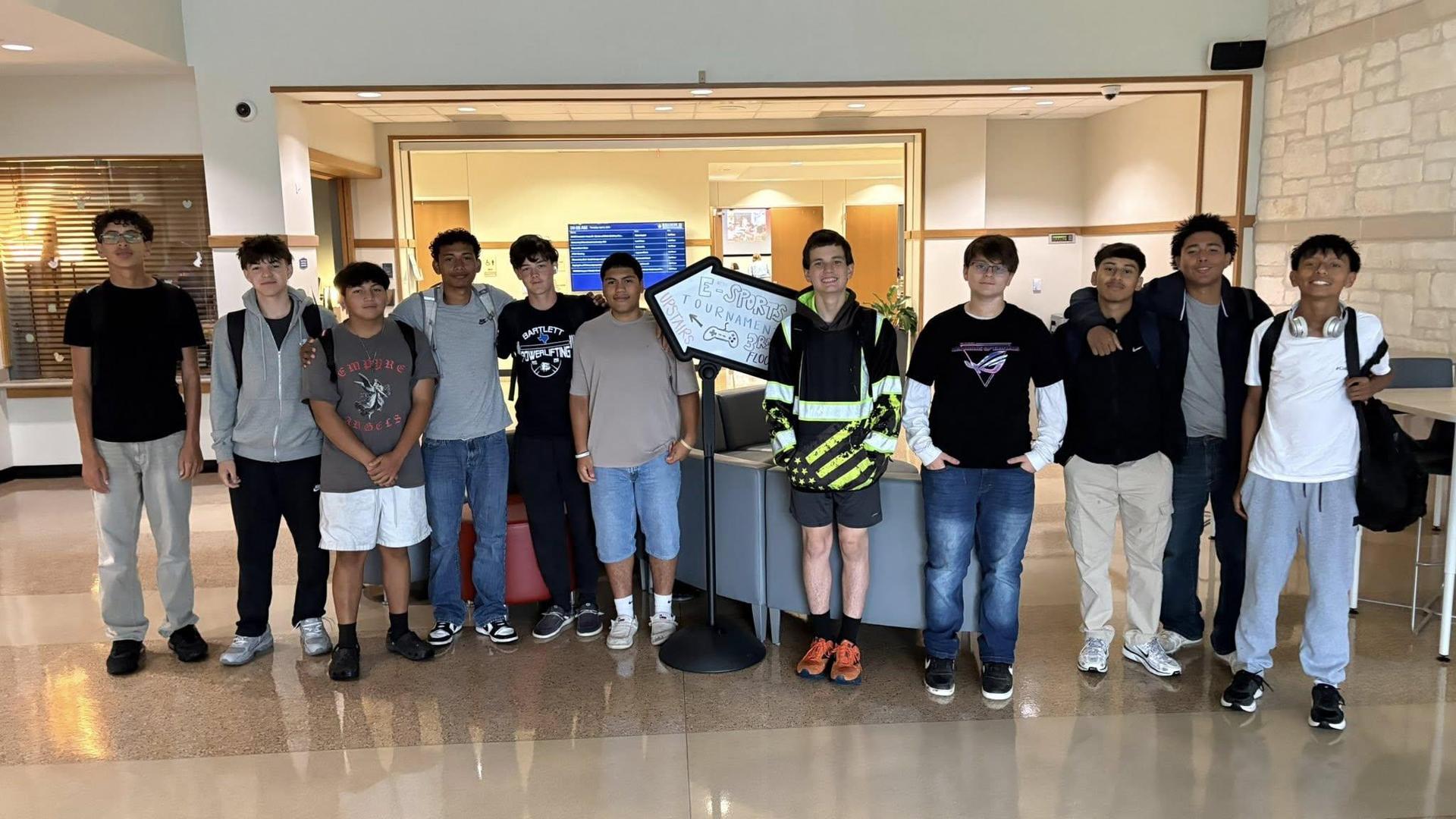 Group of teenagers posing together in a school lobby.
