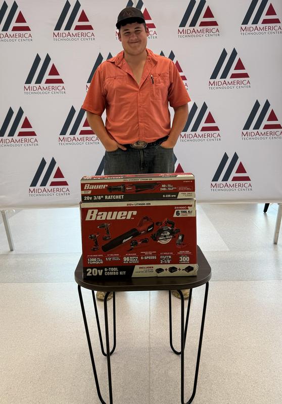 student standing behind a small table with tools