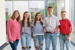 Group photo of the Heritage Middle School students holding the award.