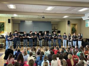 chorus stands in front of seated audience