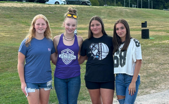 4 students in field posing for photo