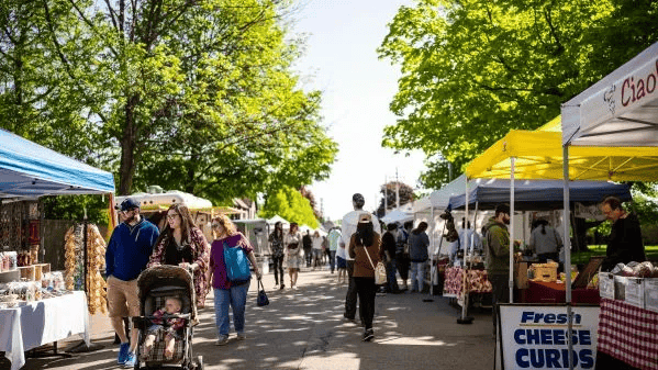 Crowded street with people walking through colorful tents of vendors for a spring festival