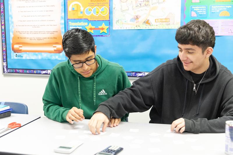 Two male students working together in class.