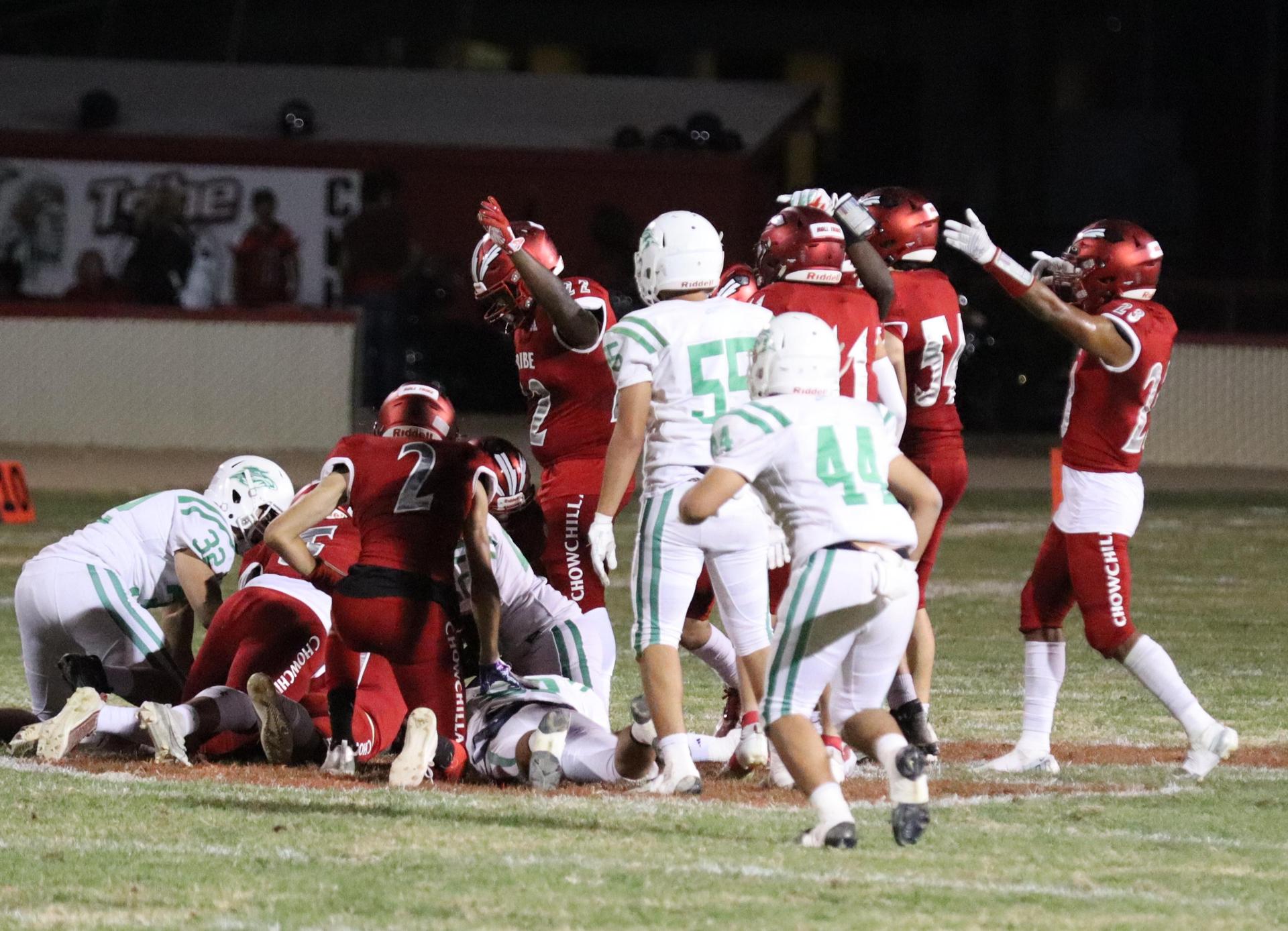 varsity football players in action against Riverdale