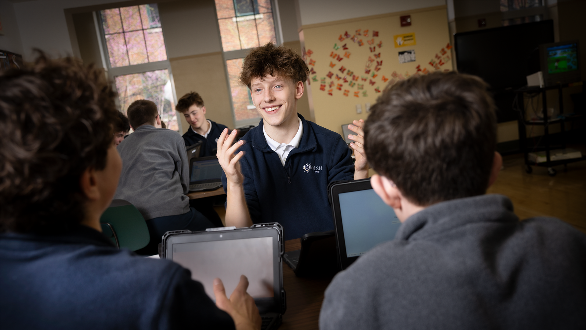 student talks with other students in OLSH library