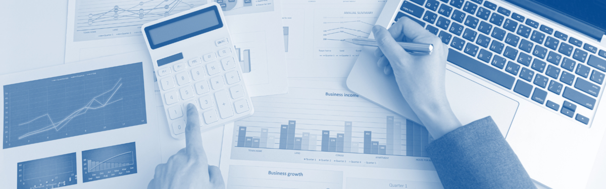 A photo of a desk cluttered with financial documents and a calculator. 