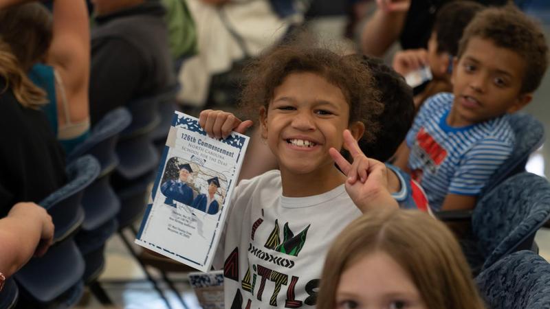 Image of student smiling while holding an award