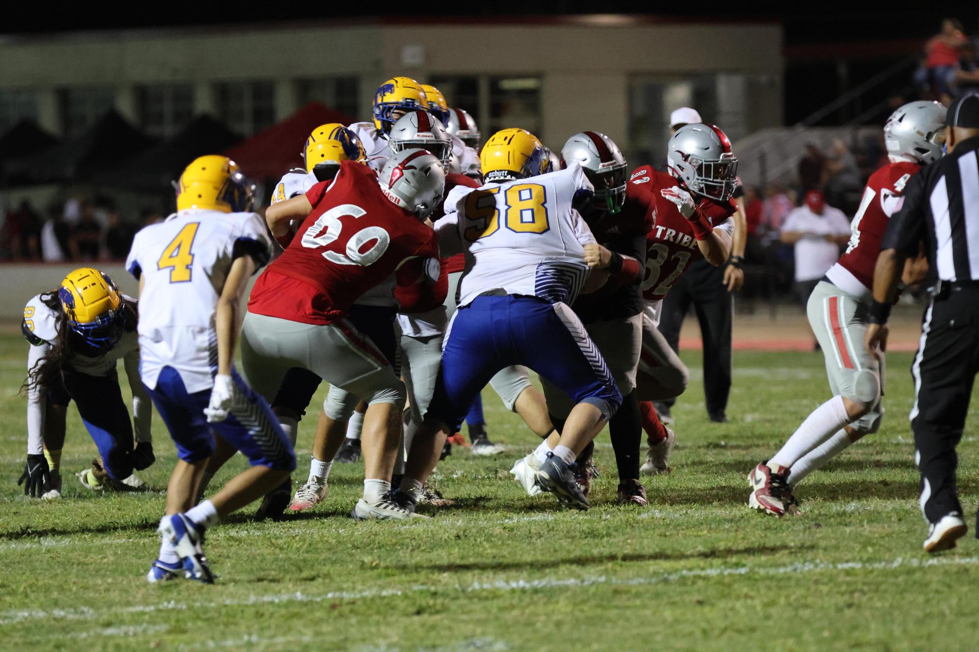 Varsity football players in action against Parlier 106