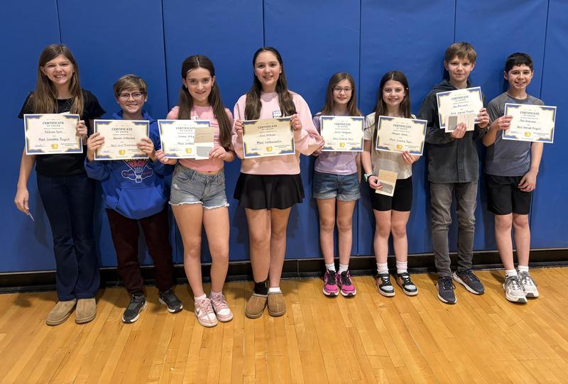 A group of eight students holding certificates