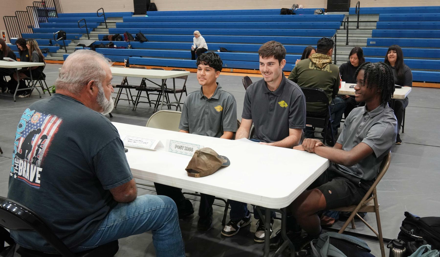 Three SJLA students interviewing a Veteran