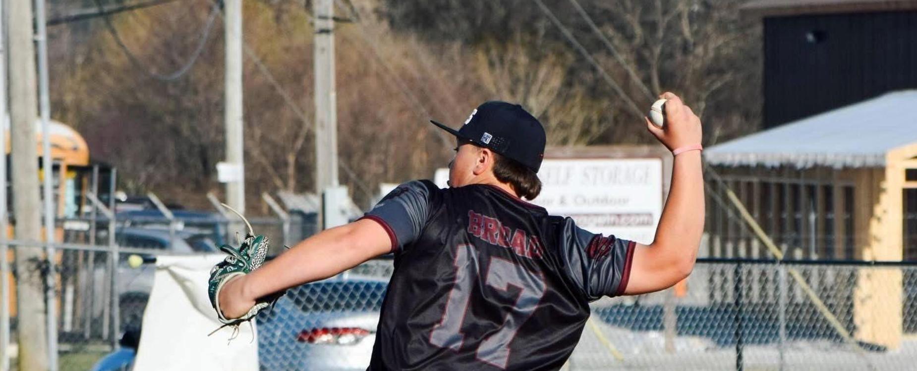 A young baseball player throwing a pitch on a field.