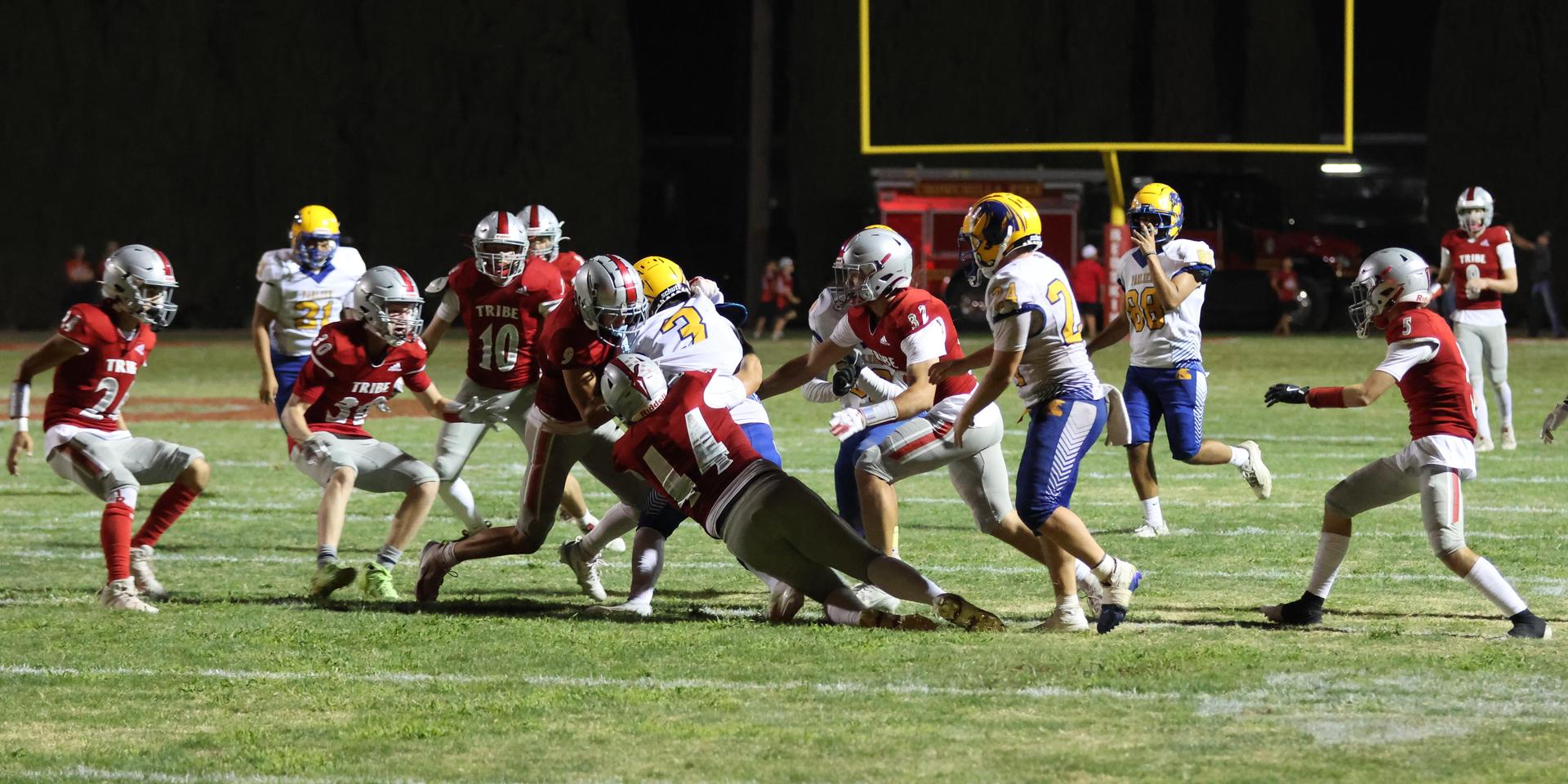 Varsity football players in action against Parlier 74