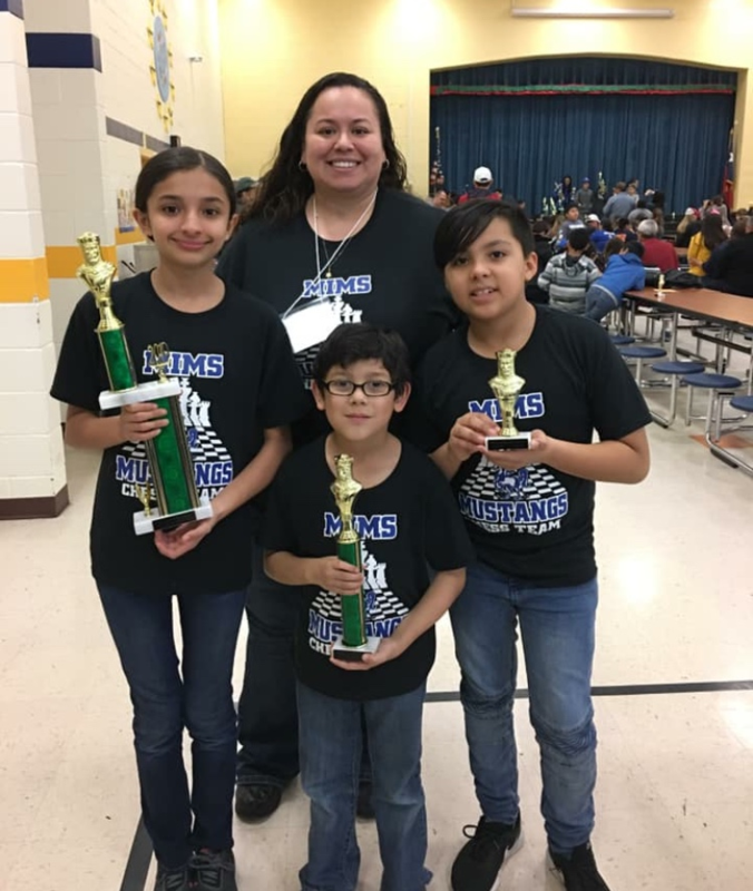 students holding trophies with their coach