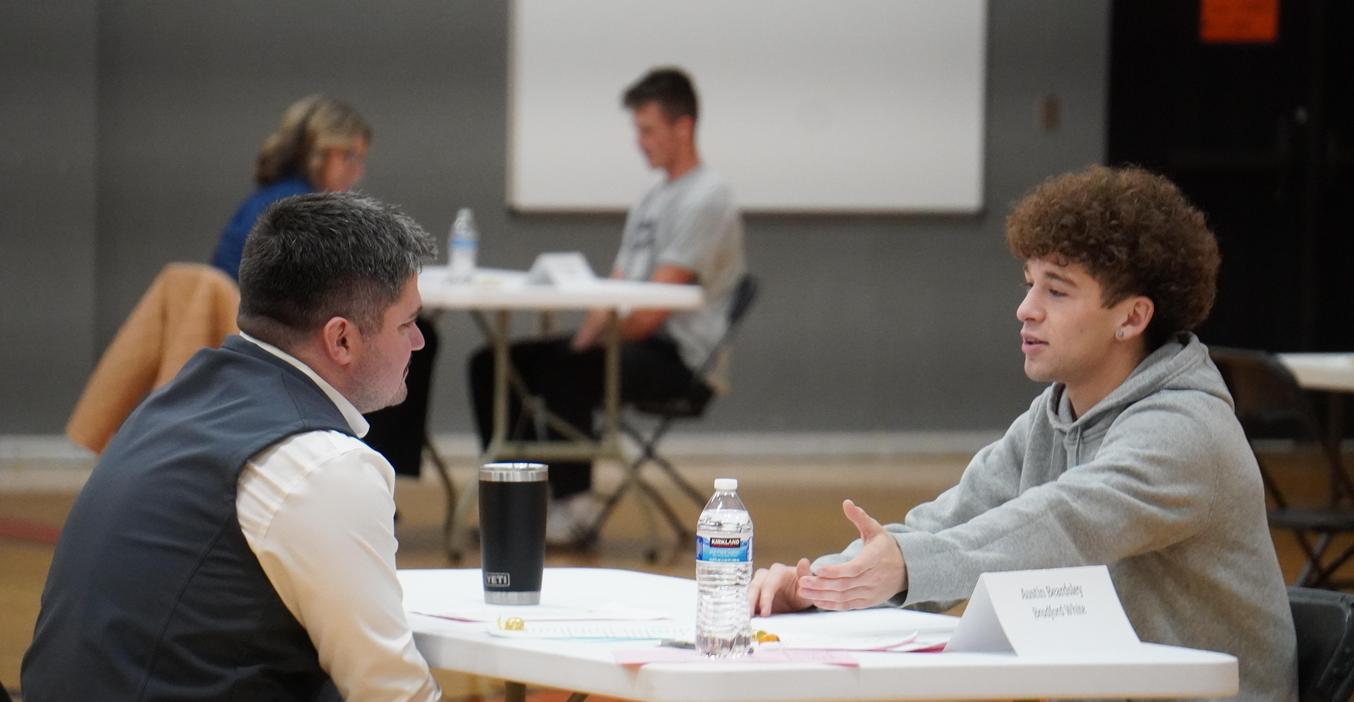 A TKHS senior goes through a mock interview process with a community volunteer.