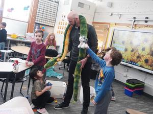 McFall Principal Mr. Sleeman drapes one of the long stuffed snakes around his neck.