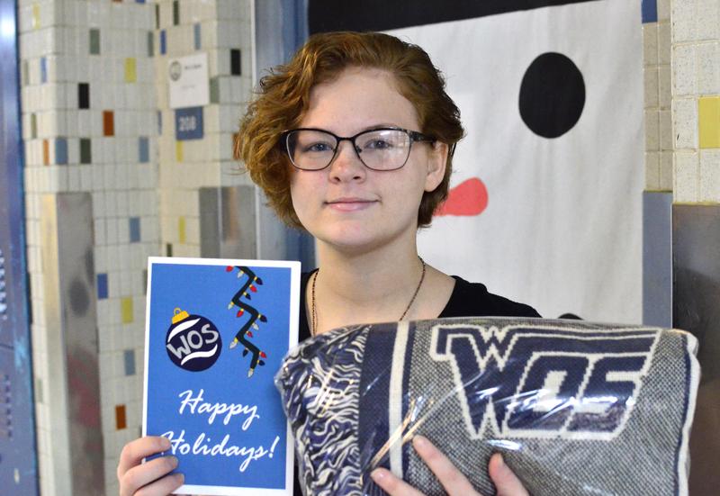 Student holds winning art design and prize