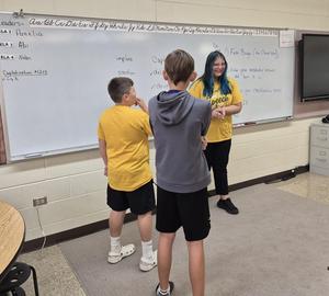 Students act out scenes using the meaning of a word