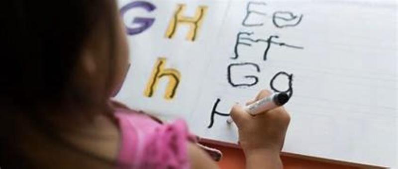 Student struggling with writing letters in the alphabet