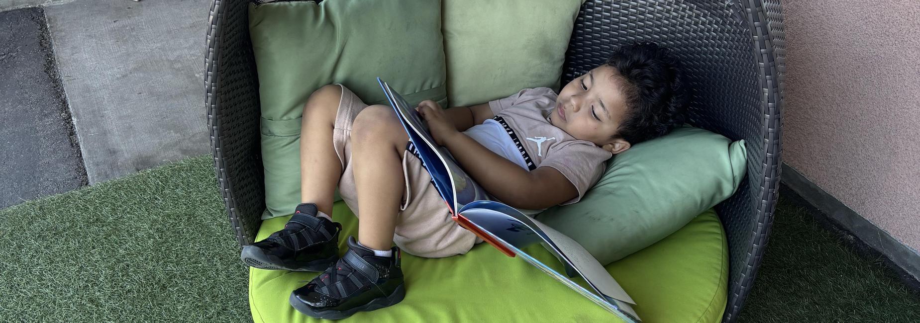child reading a book in cozy area