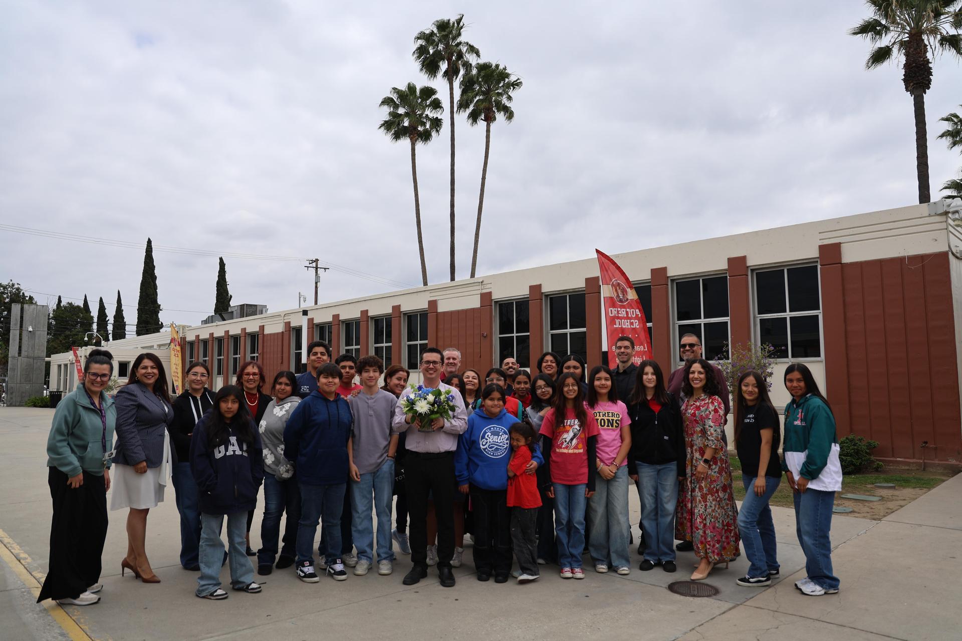 Group of admin and staff posing for a photo with teacher of the year