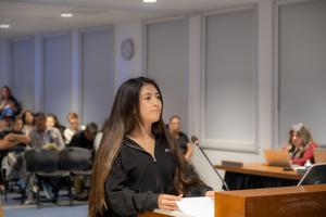 student recites her presentation infront of public and school board