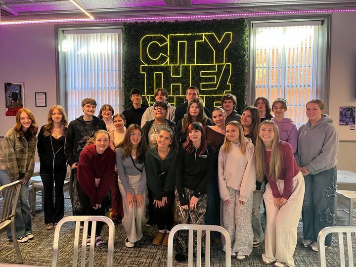 students in front of city theater sign