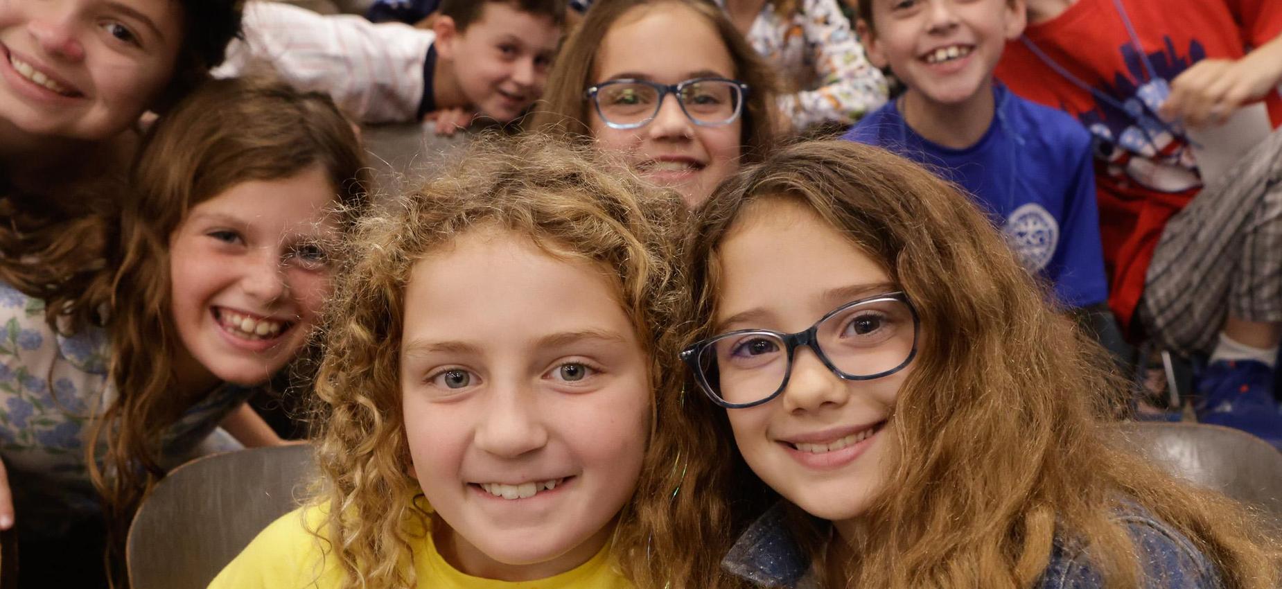 Group of smiling children posing together at an event.
