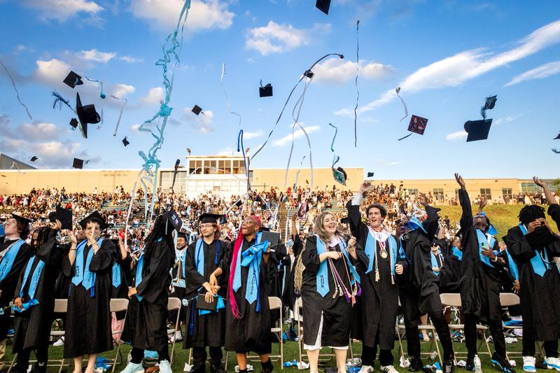 Students toss their caps into the air at graduation