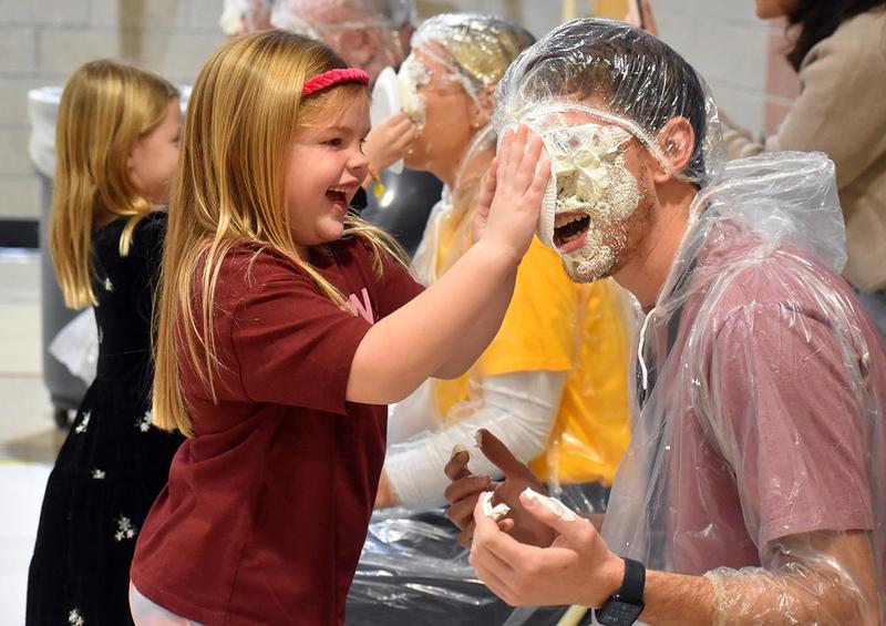 a student tossing a pie into a teacher's face