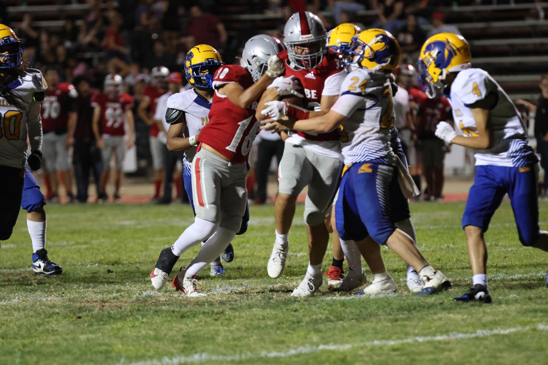 Varsity football players in action against Parlier 115