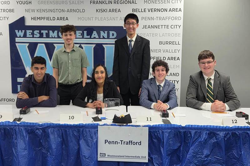 Penn-Trafford Quiz Team members  are seated at a table at the competition