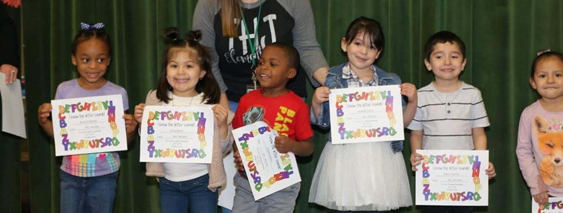 Students hold up awards