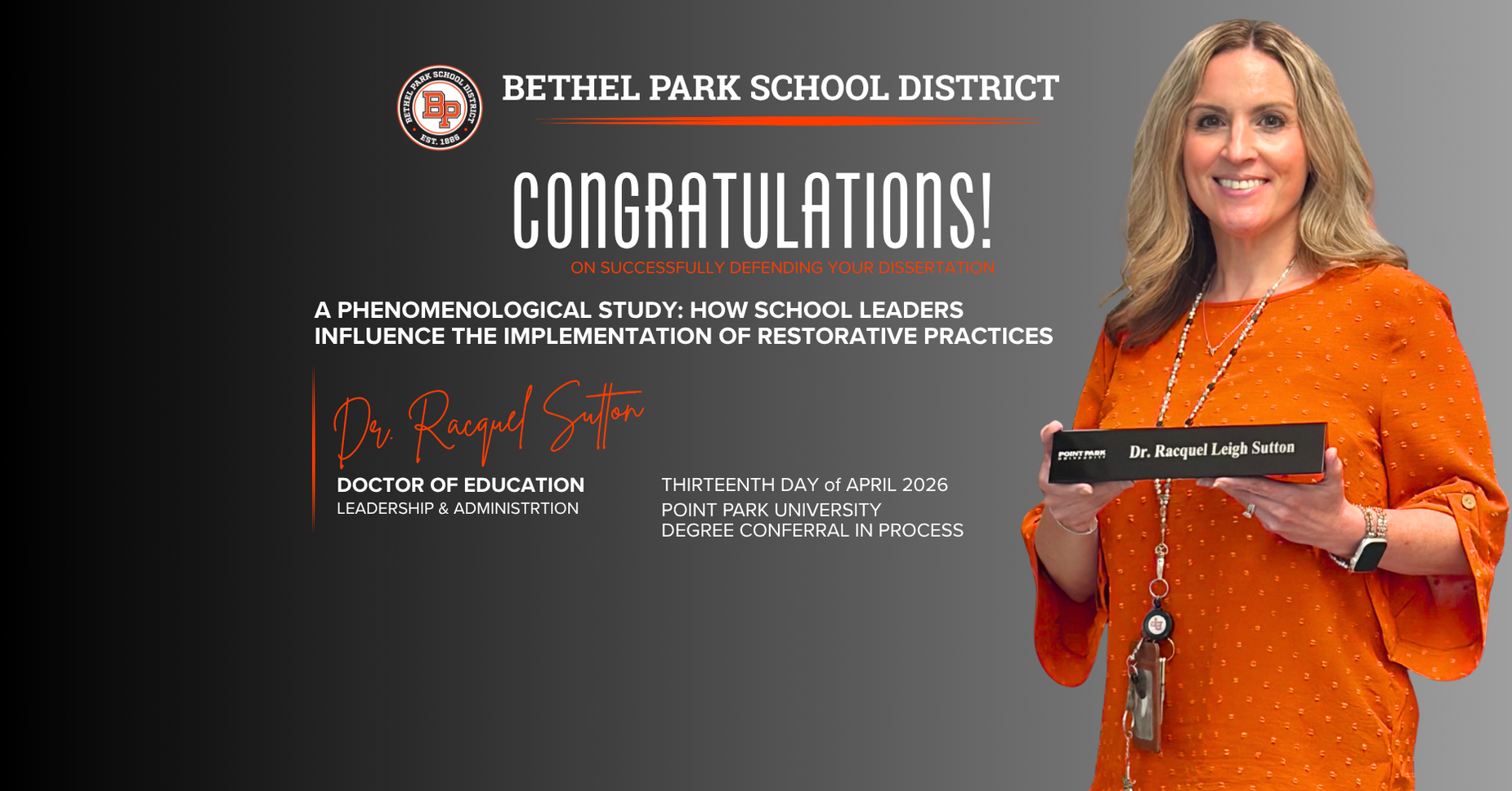 Certificate presentation by a woman in an orange blouse, celebrating a doctoral achievement.