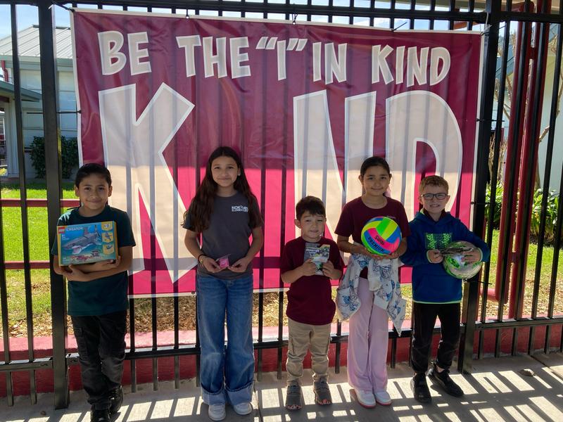 Students holding a toy, standing on the Be the 