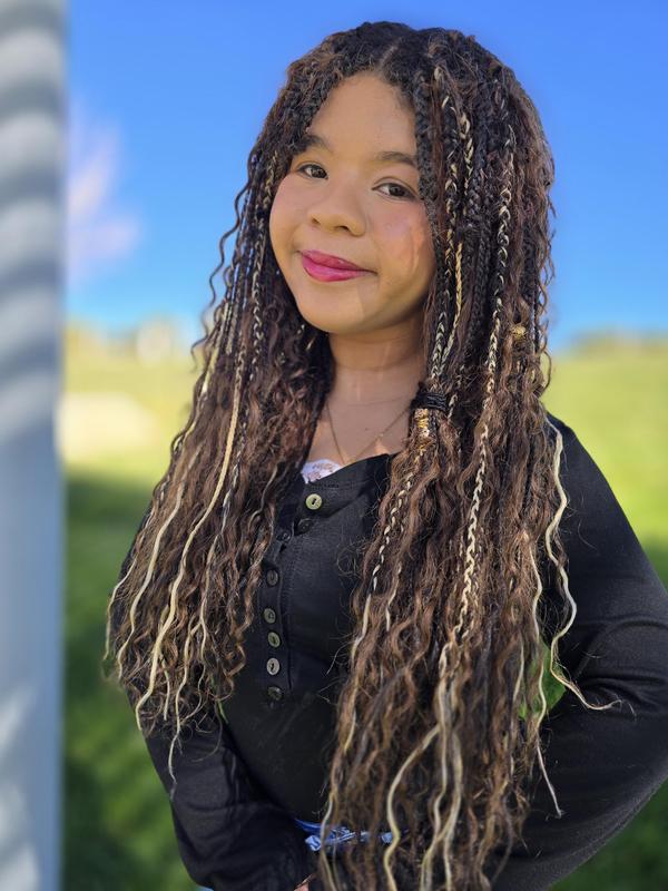 woman smiling with long brown hair and a blurred background