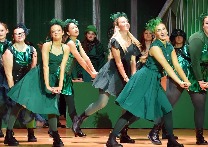 girls wearing green dresses dancing on stage