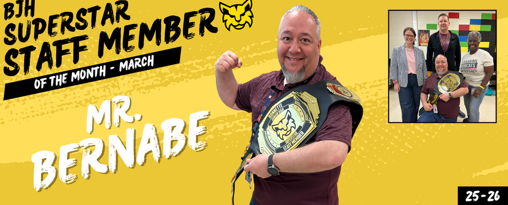 Man holding a championship belt, celebrating staff recognition with colleagues.