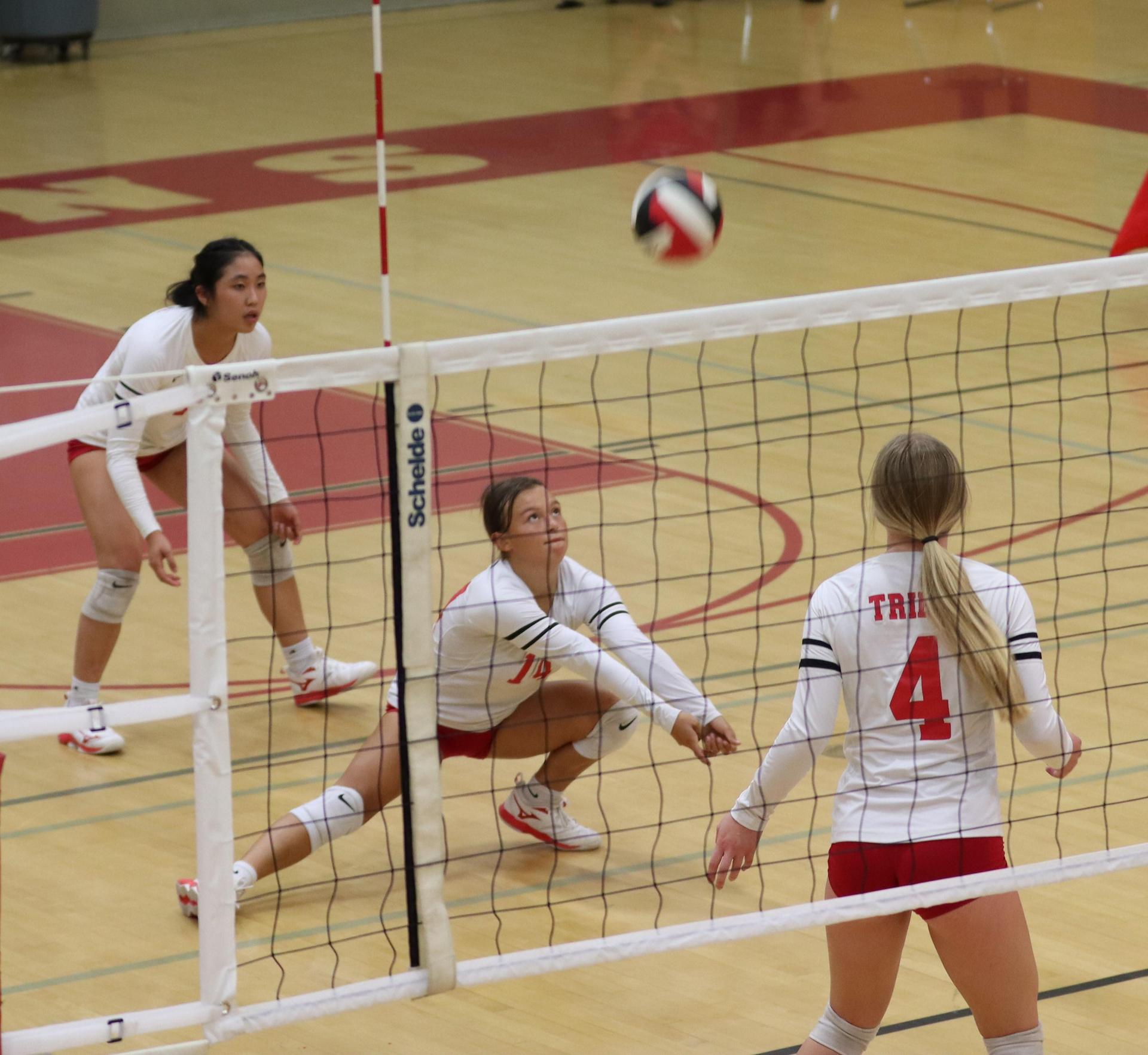 varsity volleyball players in action against Fresno Christian